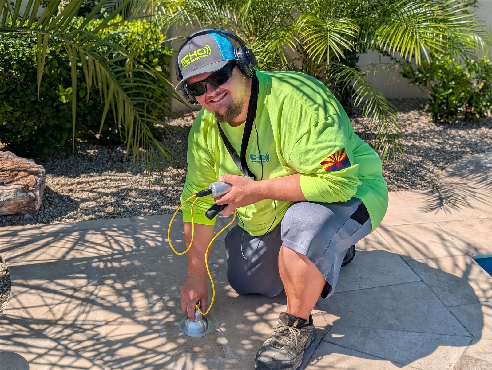 Echo Leak Detection technician using acoustic listening equipment beside a pool