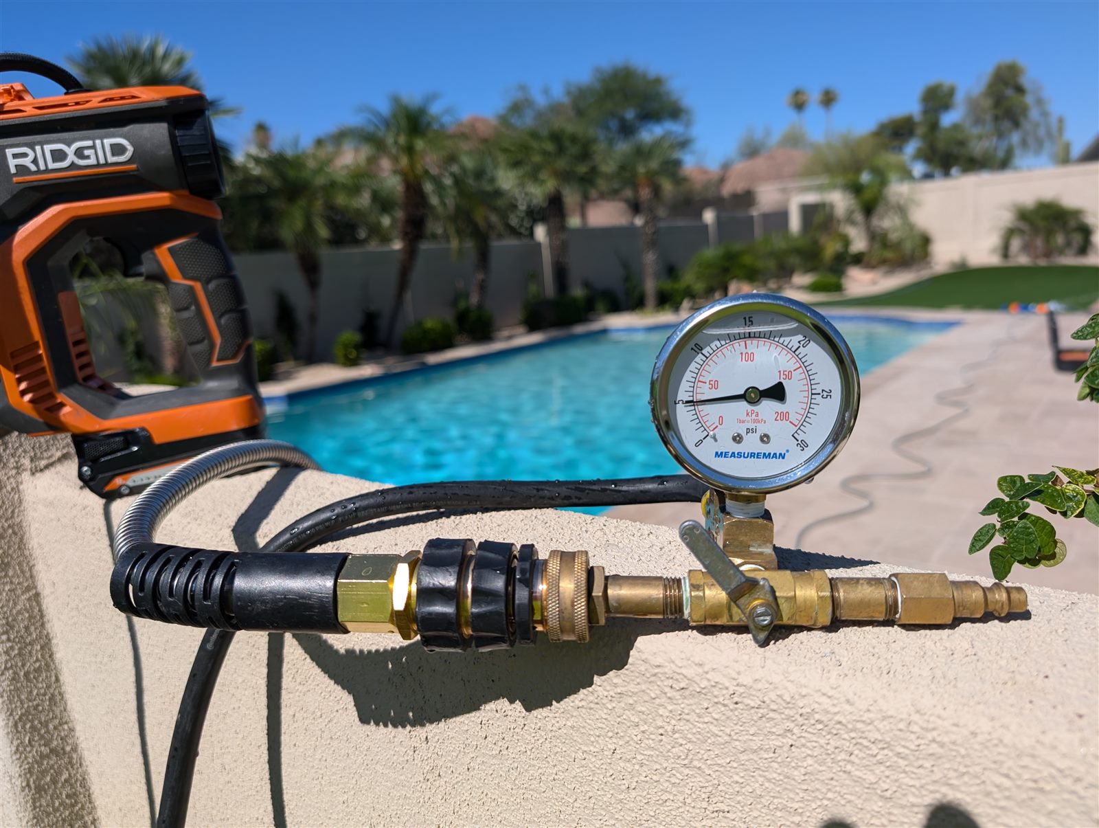 Pool plumbing pressure gauge set up beside a Phoenix-area swimming pool